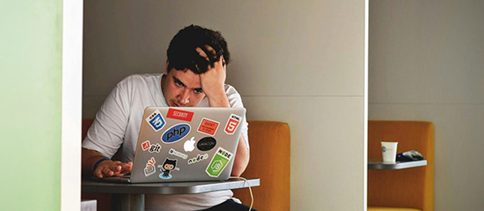 An engineer looks frustrated in a cubicle to illustrate the challenge of dealing with technical debt An engineer looks frustrated in a cubicle to illustrate the challenge of dealing with technical debt